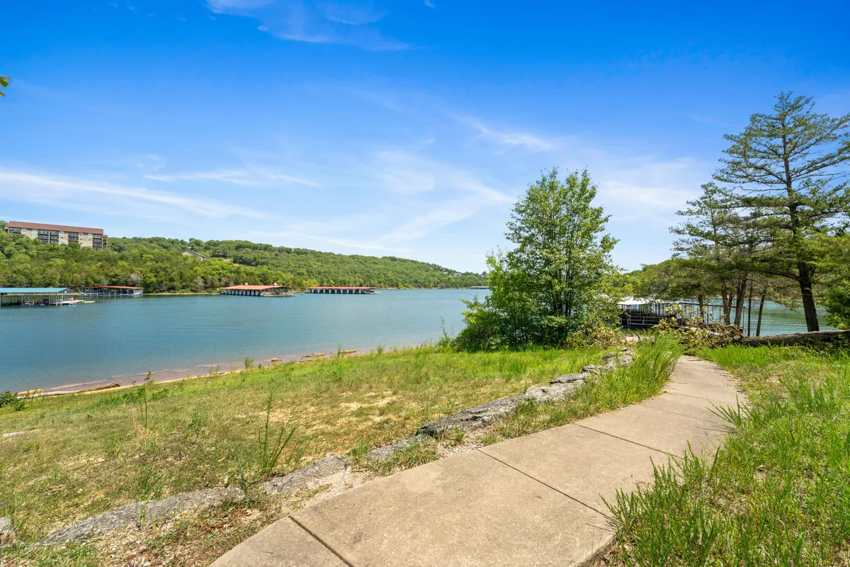A peaceful pathway running alongside a lake, surrounded by greenery. The pathway is inviting for morning or evening walks, reinforcing the pet-friendly, active lifestyle available at the property.