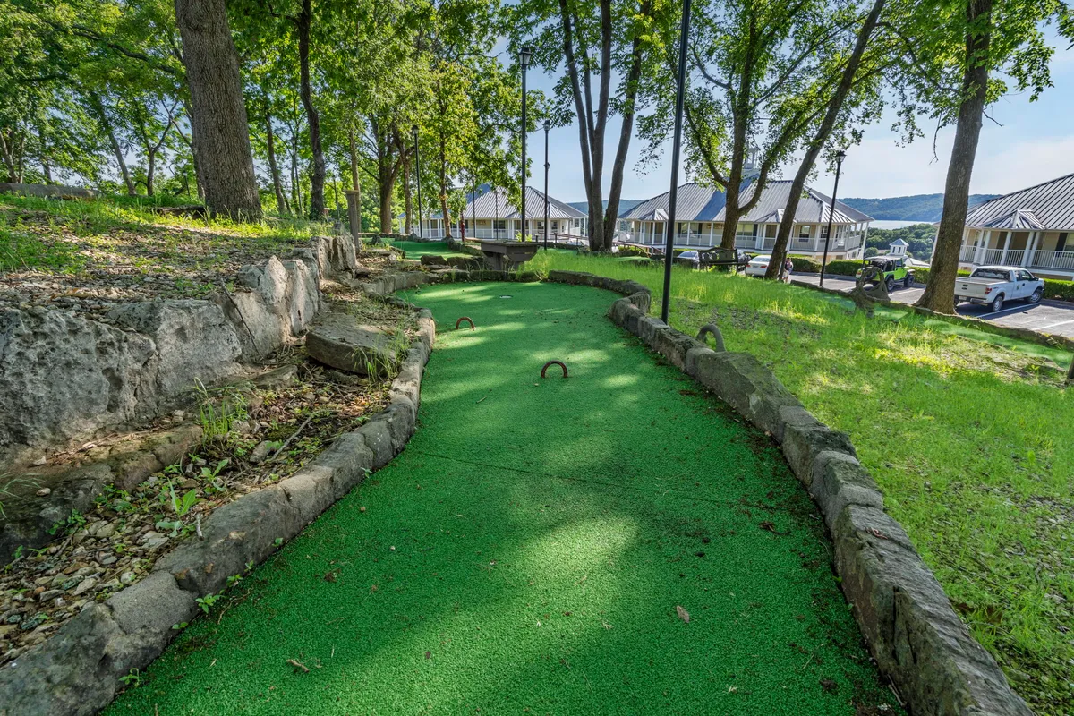 A vibrant exterior view of the mini-golf course nestled in lush greenery with winding stone pathways, designed for family outings, friendly competition, and outdoor enjoyment. The joyful mood captures the essence of shared laughter and bonding moments.