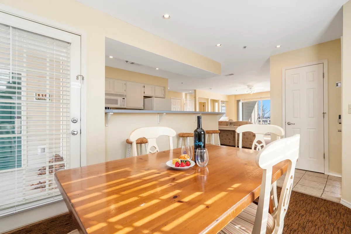 An inviting dining space featuring a dining table set with a bottle of wine and a plate of strawberries. The mood is warm and festive, suggesting moments of shared meals and celebration.