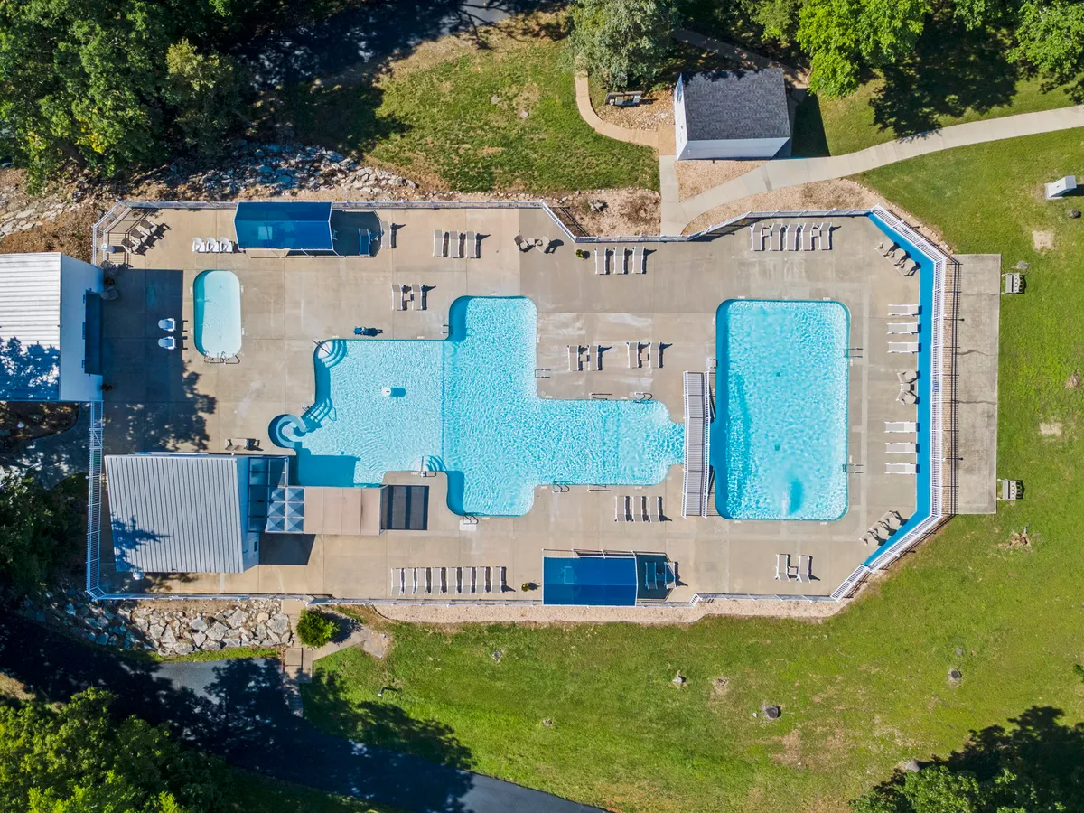 A sunny exterior scene featuring the resort’s swimming pools surrounded by sun loungers and lush greenery, inviting families to swim, sunbathe, and enjoy time together outdoors. The playful and relaxed atmosphere suggests an ideal spot for poolside fun and social gatherings.